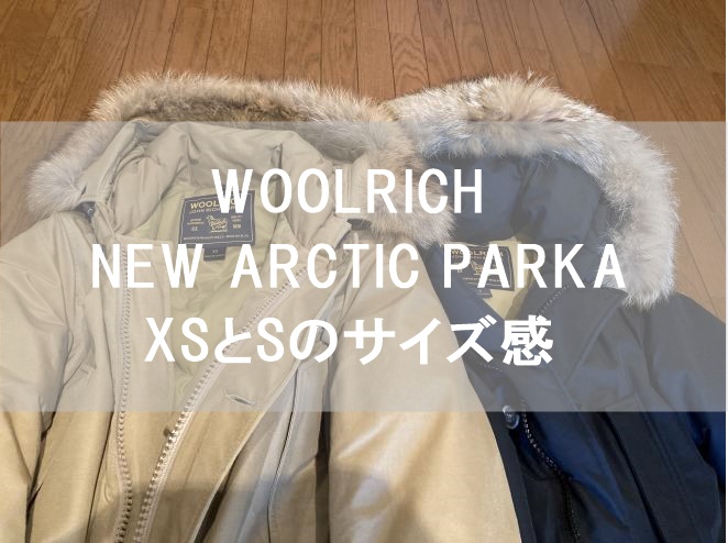 WOOLRICH NEW ARCTIC PARKAのXSベージュとSダークネイビーを並べて撮影した画像にキャッチコピーを入れたアイキャッチ画像
